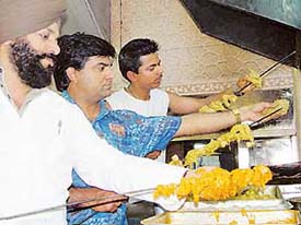 Chefs spike the special green tandoori chicken at Chawlas chicken. Tribune photo: Malkiat Singh