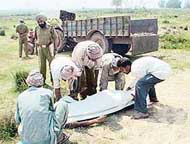 The body of Kishen Lal being picked up from an open field in Nano Majra village near Sohana 
