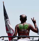 An activist of AIADMK poses with the party logo painted on his back at a rally in Chennai 