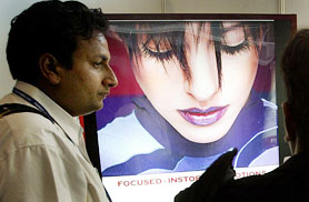 A visitor to looks at a Bollywood advertisement at Frames 2004, a global convention on entertainment business, in Mumbai on Monday