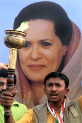 A Congress supporter holds a torch at an election campaign rally in Jammu 