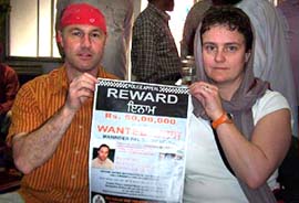UK police officer Allen Baits shows a poster announcing a cash reward for clue on a rape and murder accused in Amritsar on Monday.