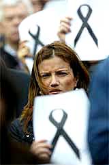 An unidentified European Union employee holds a poster with a black ribbon of mourning for the victims of the deadly Madrid blasts which killed 200 persons