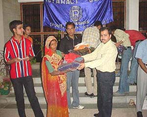 Pankaj Lakhanpal, secretary of the Rotary Club, Hamirpur, gives blankets to the families of the poor