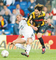 Real Madrids Zinedine Zidane (L) and Real Zaragozas David Villa try to control the ball during the Spanish First Division soccer match at Madrids Santiago Bernabeu Stadium on March 13. The match ended in a 1-1 draw.