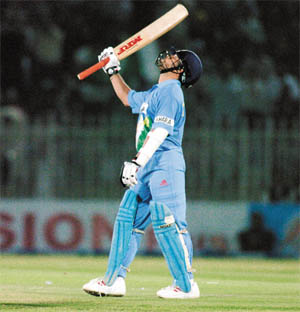 Sachin Tendulkar raises his bat after completing his century in the second ODI against Pakistan