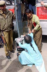 A police woman drags a protester during a demonstration by the Parents of Disappeared Persons Association at Lal Chowk in Srinagar