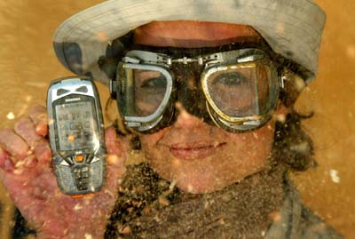 A model poses with the new Siemens M65 outdoor cellphone with improved protection against splashed water and dust while standing in an artificial sandstorm on the booth of Siemens mobile at the CeBIT in Hanover.