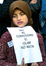 A young Muslim immigrant holds a poster reading 'No to terrorism, Islam does not kill' during a rally to pay tribute to the victims of the Madrid train bombings