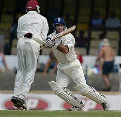 England's Graham Thorpe hits a shot as Ramnaresh Sarwan of the West Indies jumps out of the way on the fourth day of the second Test in Port of Spain 