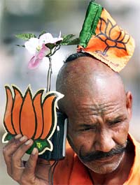 A BJP supporter listens to radio as he sports the partys symbol and flag at Chandigarh