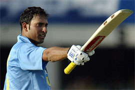 V.V.S. Laxman raises his bat after reaching his century
