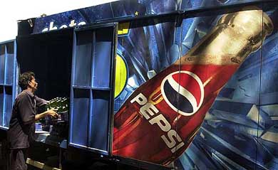 A man loads crates of small Pepsi bottles in a truck in Mumbai