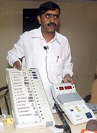 An Election Commission officer displays an electronic voting machine that will be used in the Lok Sabha elections, at a press conference in New Delhi 