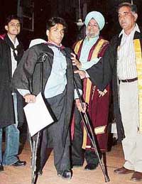 B.Com graduate Sanjeev Sharma after receiving his degree being helped by the principal & staff of Government College, Sector 11