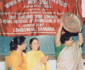 Somadutta Mandal raises a plaque at the conference