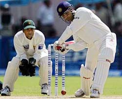 Virender Sehwag prepares to hit a shot as Pakistani wicketkeeper Moin Khan looks on 
