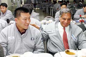 Tata Motors Chairman Ratan Tata sits with an employee of Daewoo Motors in South Korea on Monday