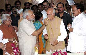 Gujarat Chief Minister Narendra Modi offers sweets to Deputy Prime Minister L.K. Advani after the latter filed his nomination papers in Gandhinagar on Monday