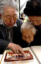 South Korean Jeon Dae-bok shows a family photograph to his North Korean sister Jeon Og-nyo and niece Kang Man-hong at a resort in North Korea 