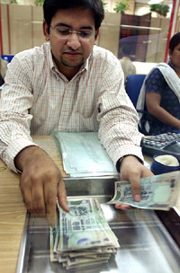 An Indian forex dealer counts rupee notes during busy market hours in a foreign exchange firm in Mumbai on Wednesday.
