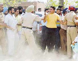 A cop tries to arrest a boy, who was allegedly involved in a scuffle outside the judicial complex in Ludhiana on Wednesday.
