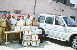 The accused with the seized cases of IMFL in Ludhiana