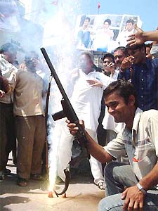 Cricket fans fire in the air during a victory procession after India's historical victory over Pakistan