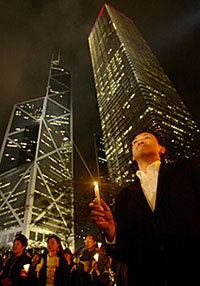 Pro-democracy protesters hold a candlelit vigil at Hong Kongs financial central district on Thursday. Hundreds staged protests to condemn Beijings imminent review of the local constitution. 