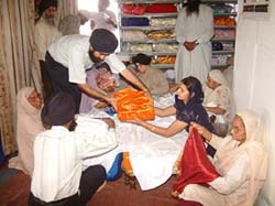 The birs of Guru Granth Sahib being wrapped in rumalas as per Sikh tradition at Gurdwara Ramsar, Amritsar, before being carried to Toronto in a charted aircraft on Saturday.