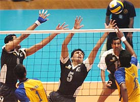 Indias Tom Joseph hits a ball over the net and Pakistans Muhammad Tufail puts up a defence during the volleyball final in Islamabad