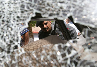 A Pakistani official inspects a car which was used by unknown assailants to attack a police station in Karachi on Sunday 