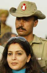 Ajit Agarkar's wife Fatima Agarkar poses for a photograph as a Pakistani soldier stands guard 