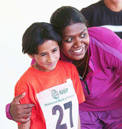 Sri Lankan sprinter Susanthika Jayasinghe poses with 12-year-old Afghan athlete Meena Berek Zai 
