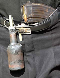 An Iraqi militiaman aligned with Shiite cleric Moqtada al-Sadr wears a makeshift grenade on his belt 