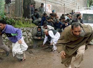 People run for cover after an attack during an election campaign rally in Uri, 102 km from Srinagar
