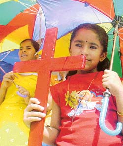 A girl carries a cross during a procession on the occasion of Good Friday 
