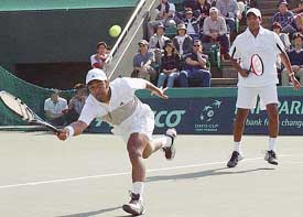 Leander Paes reaches out to the ball as his team-mate Mahesh Bhupathi looks on during a doubles match against Japanese pair Thomas Shimada and Takahiro Terachi
