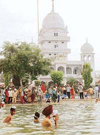 Devotees take a dip in the sarovar of Gurudwara Alamgir Sahib