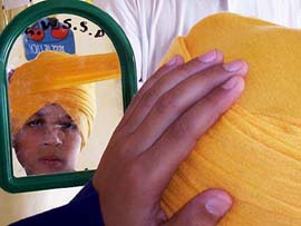 A boy tries a turban at a competition in Patiala on Wednesday on the occasion of Baisakhi
