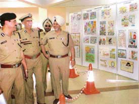Senior police officials have a hearty laugh at the cartoons made by students of different schools of Ludhiana at a traffic awareness function