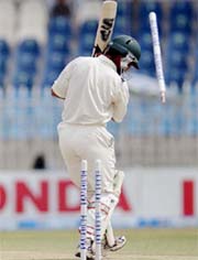 Pakistans Kamran Akmal is clean bowled by Laxmipathy Balaji