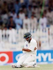 Pakistans Asim Kamal sits on the ground after the dismissal of Mohammad Sami