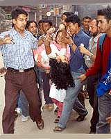 A Nepalese activist injured by a projectile is carried to a hospital in Kathmandu following a violent protest on Monday