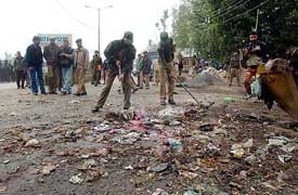 Jammu and Kashmir police personnel look for clues after a blast at Khanayar
