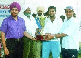 The Inborn Cricket Club captain receiving the Ranjit Singh Cricket Tournament trophy from GHPS principal S. S. Minhas