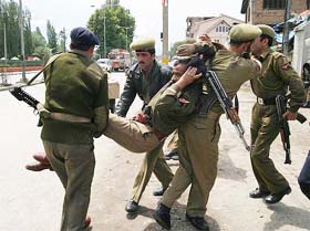 Paramilitary jawans carry away their wounded colleague after a grenade attack on the Congress Headquarters in Srinagar