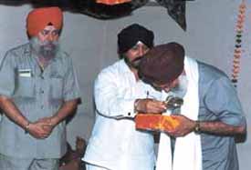 Mr Harinderpal Singh, member, SGPC, Amritsar, giving a siropa and a memento to Mr H. S. Matharoo, general secretary, DSGMC. Also seen in the picture is Mr Tehal Singh
