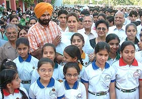 BJP candidate Navjot Sidhu and his wife pose for a photograph with schoolchildren in Amritsar