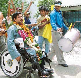 Javed Abidi, Chairman of the Disabled Rights Group, is cheered as he goes to file his nomination papers for the New Delhi seat